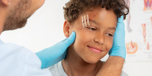 Ein Kind mit Wundnahtstreifen am Auge Ein Kind mit Wundnahtstreifen am Auge